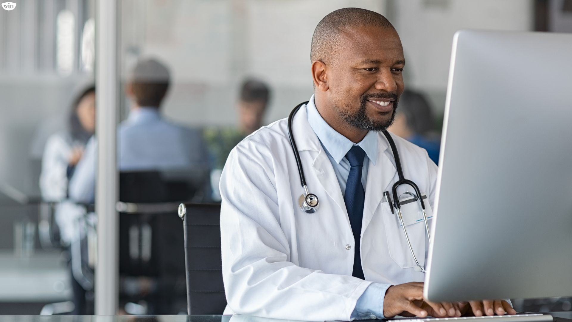 A doctor working on a desktop computer