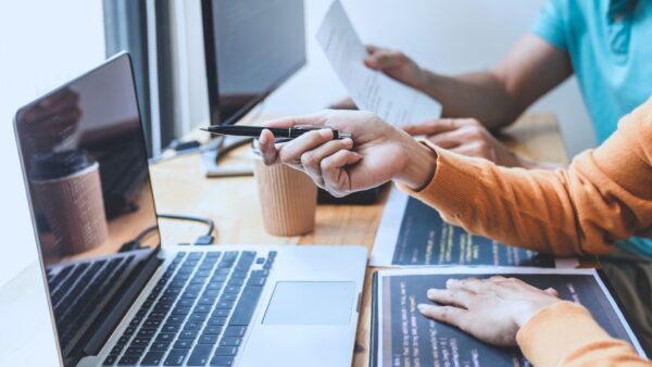 Two business professionals working at their laptops